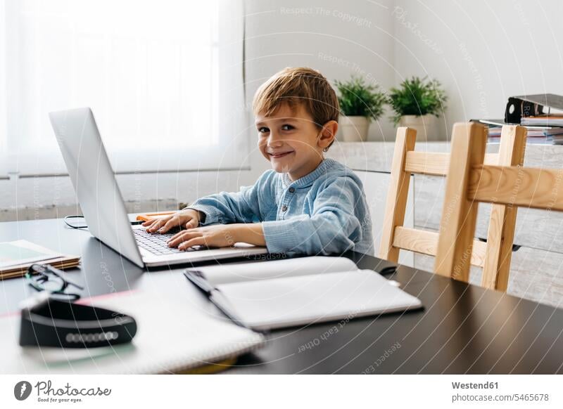 Little boy sitting in his father's office, using laptop use desk desks Laptop Computers laptops notebook working At Work Seated boys males Table Tables computer