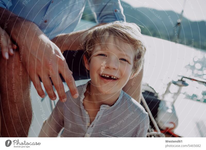 Smiling boy with parents on a sailing boat sailboat Sail Boat Sailboats sailing boats boys males portrait portraits happiness happy family families smiling