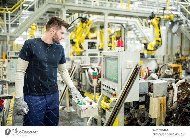 Man working in a modern factory operating a machine Occupation Work job jobs profession professional occupation blue collar blue collar worker