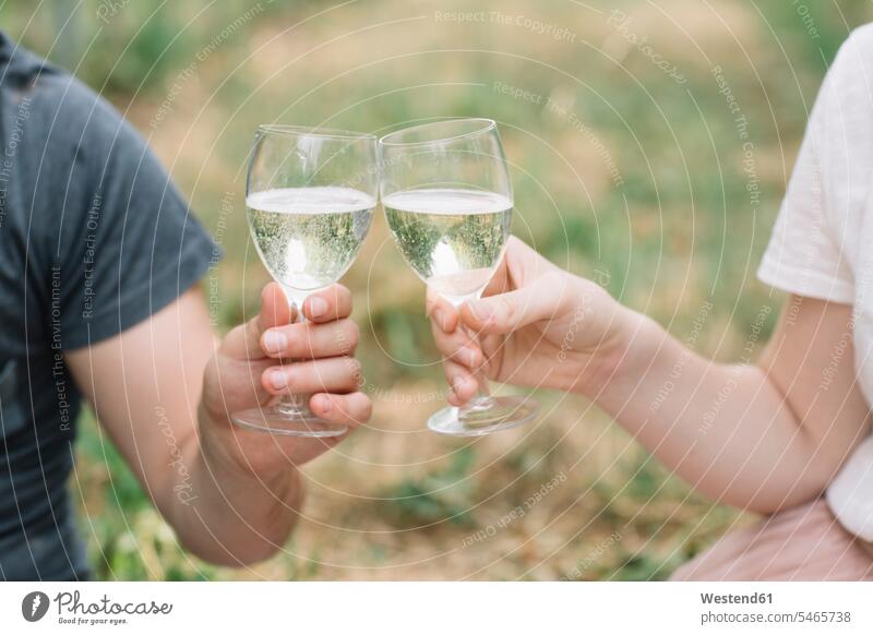 Young couple toasting with Prosecco in the vineyards, close-up hold drink country countryside free time leisure time community Alimentation food Food and Drinks