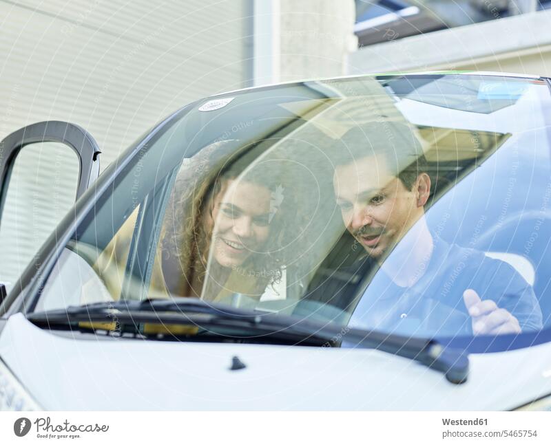 Smiling couple with electric bubble car automobile Auto cars motorcars Automobiles twosomes partnership couples smiling smile electric car motor vehicle