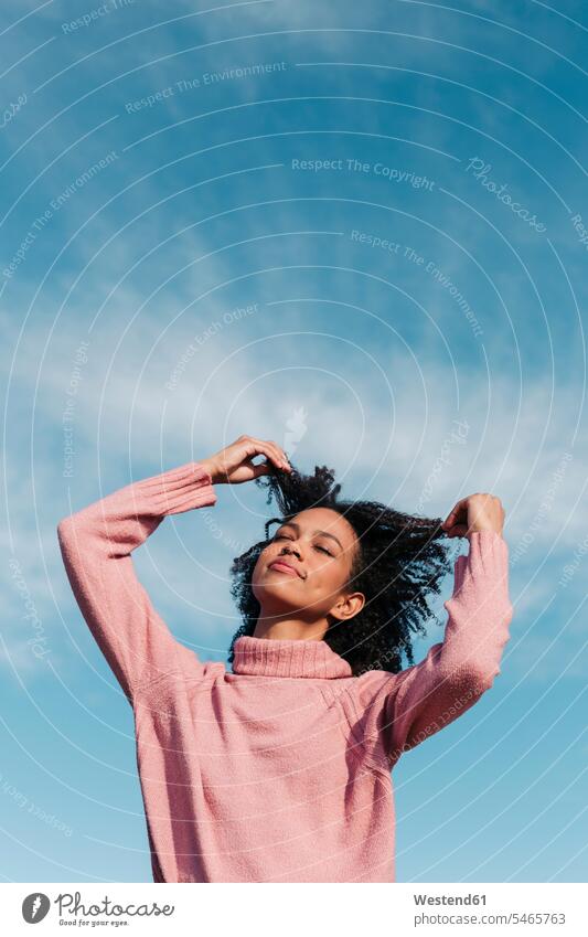 Portrait of young woman against sky touching her hair skies females women portrait portraits Adults grown-ups grownups adult people persons human being humans