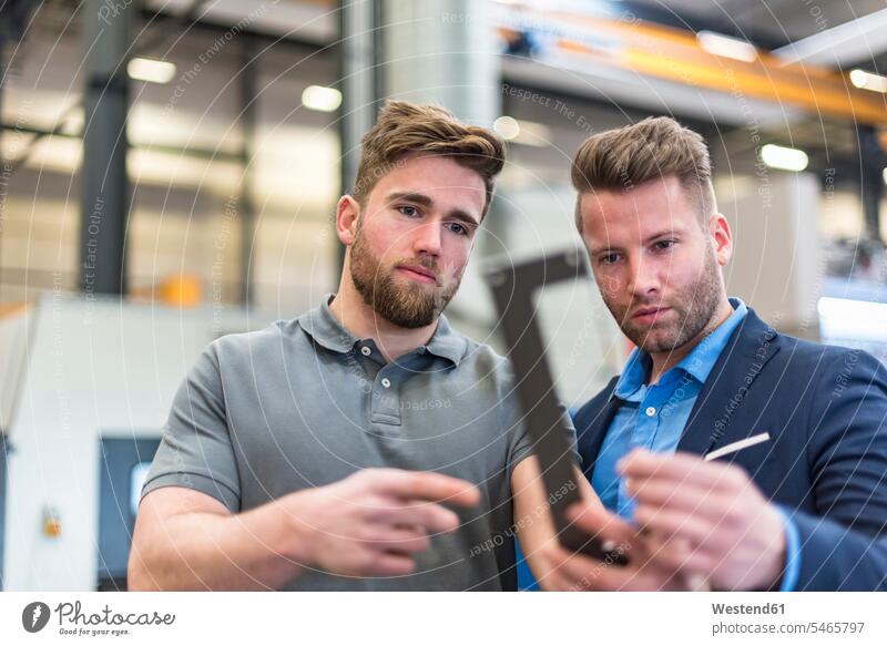 Employee and businessman examining workpiece on factory shop floor checking examine Businessman Business man Businessmen Business men employee clerk employees