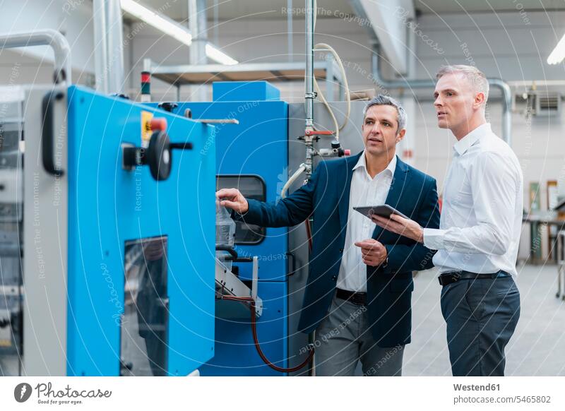 Two businessmen with tablet talking in a factory human human being human beings humans person persons caucasian appearance caucasian ethnicity european 2