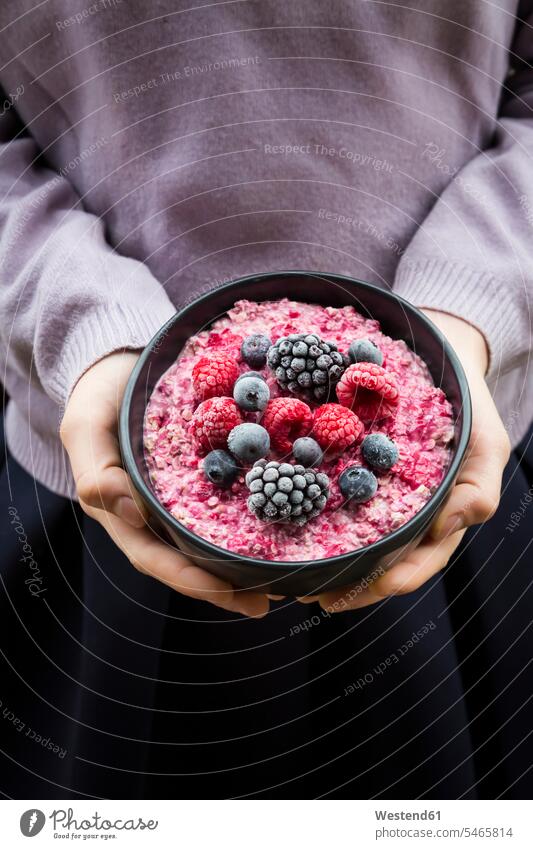 Girl holding bowl with overnight oats mit frozen berries hand human hand hands human hands Freshness fresh Raspberry Raspberries Oat Flakes rolled oats fruit