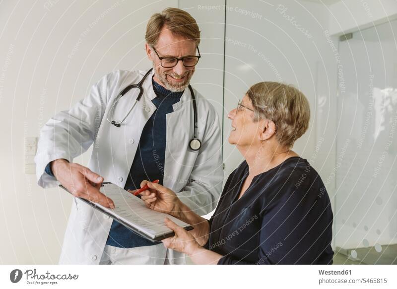 Doctor helping senior patient filling out document health healthcare Healthcare And Medicines medical medicine disease diseases illnesses sick Sickness patients