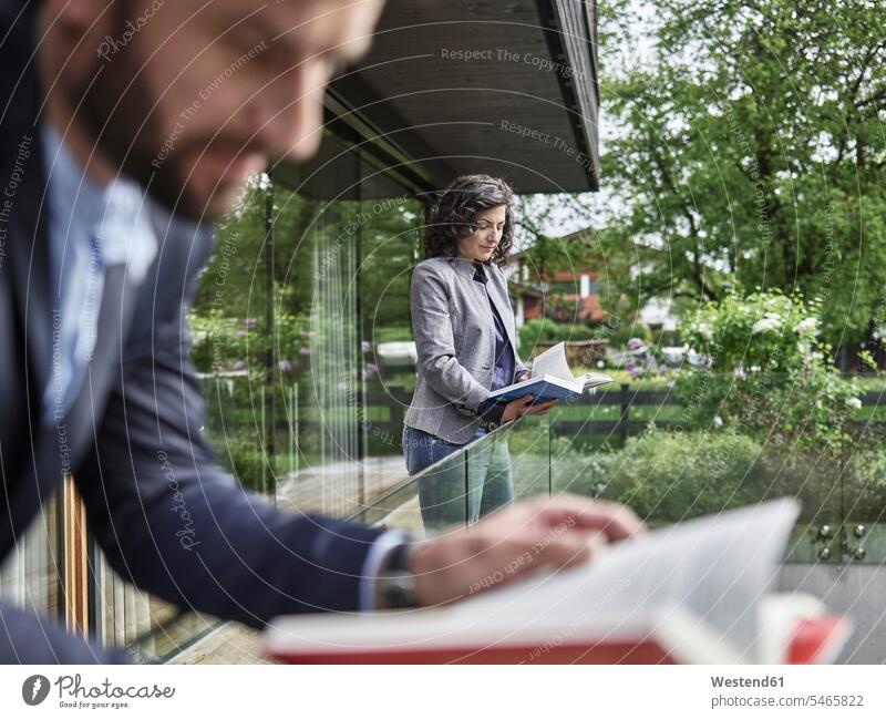 Business people reading books on balcony colleagues balconies business people businesspeople business world business life smart smart casual smart-casual
