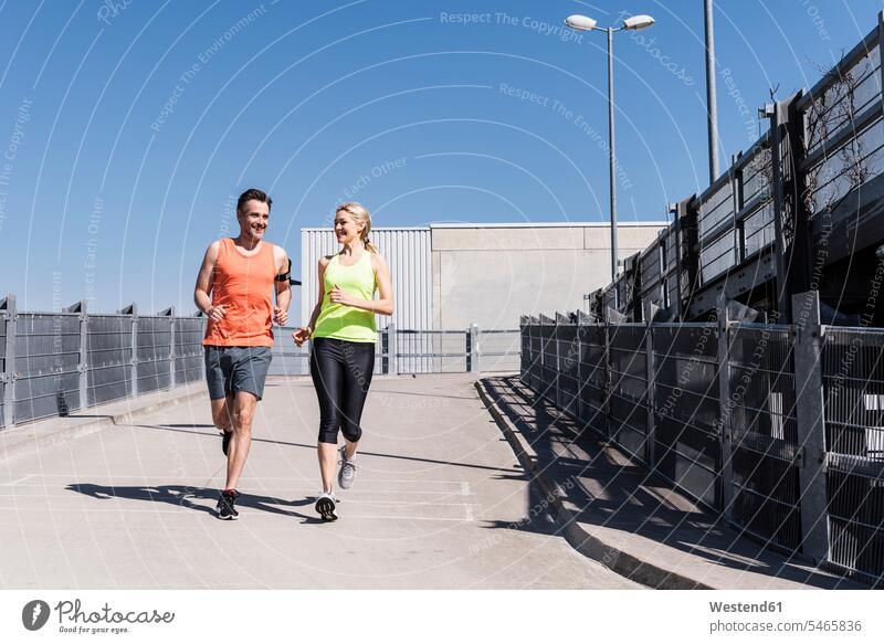 Fit couple jogging in the city jogger joggers female jogger exercising exercise training practising twosomes partnership couples sportive sporting sporty