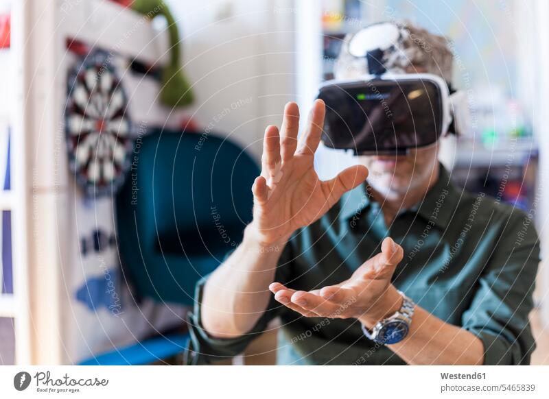 Portrait of mature man at home using Virtual Reality Glasses men males use portrait portraits VR glasses Virtual-Reality Glasses virtual reality headset