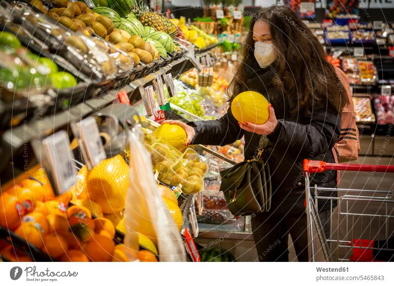 Mature woman buying fruits in supermarket during COVID-19 color image colour image indoors indoor shot indoor shots interior interior view Interiors day