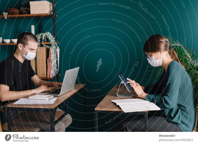 Young man and woman wearing protective masks working on desks at home colleague Occupation Work job jobs profession professional occupation business life