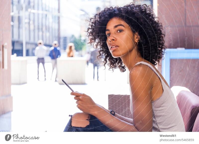 Portrait of young woman with digital tablet sitting at sidewalk cafe watching something Seated females women sidewalk cafes pavement cafes looking portrait