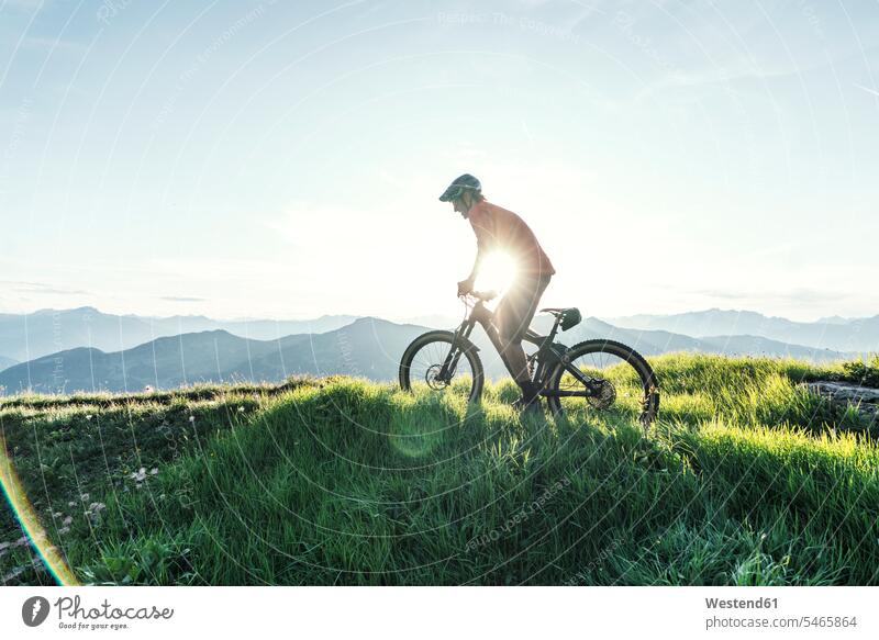 Mountainbiker against the sun on a way in Grisons, Switzerland bikes bicycles bike - bicycle Cycle Cycle - Vehicle exercise practising train training drive