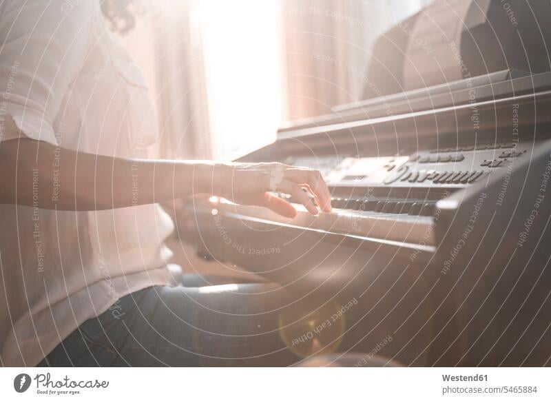 Close-up of woman playing piano windows Instrument Instruments musical instruments pianos Seated sit exercise exercising practice practise practising at home