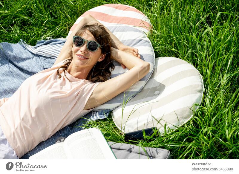 Portrait of smiling relaxed woman lying on a meadow human human being human beings humans person persons caucasian appearance caucasian ethnicity european adult