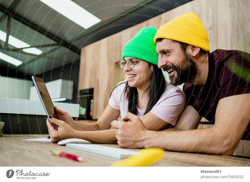Happy business couple using digital tablet at desk in modern office color image colour image indoors indoor shot indoor shots interior interior view Interiors