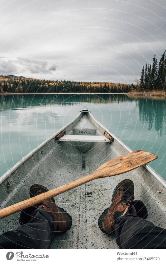 Canada, British Columbia, legs of a man in canoe on Boya Lake lake lakes men males human leg human legs water waters body of water canoes boat boats vessel