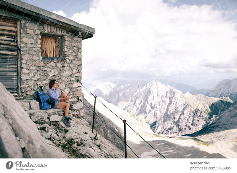 Austria, Tyrol, woman on a hiking trip resting at mountain hut mountain shelter alpine hut mountain huts mountain lodge females women building buildings