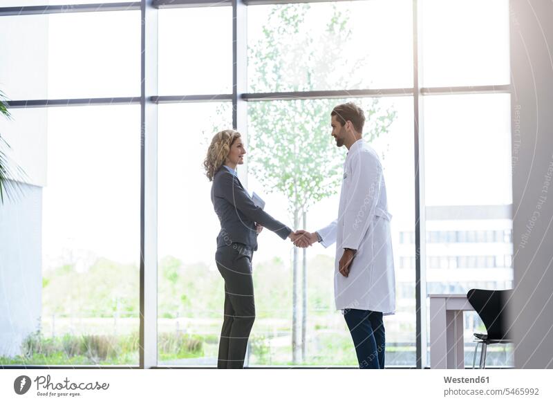 Businesswoman and doctor shaking hands in hospital Occupation Work job jobs profession professional occupation business life business world business person