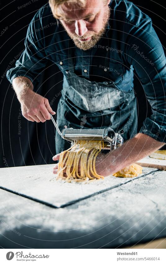 Hobby chef making fresh tagliatelle with pasta machine human human being human beings humans person persons caucasian appearance caucasian ethnicity european 1