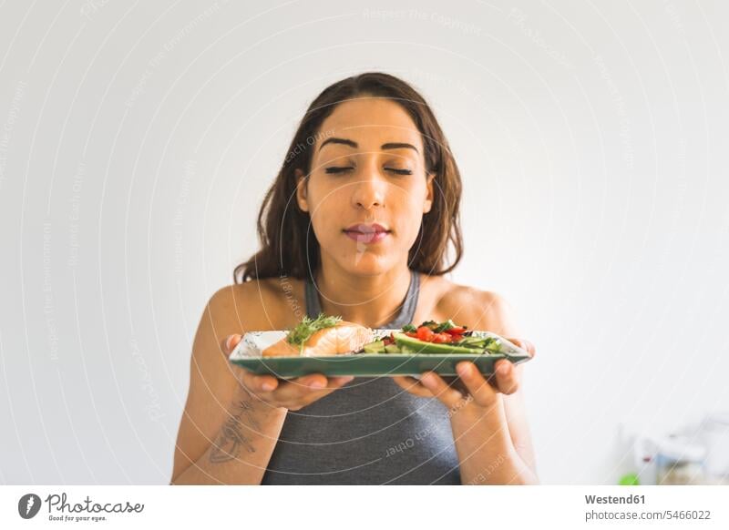 Woman holding plate with vegetables and salmon Plate dish dishes Plates woman females women Vegetable Vegetables fish food fish edible fish Food foods