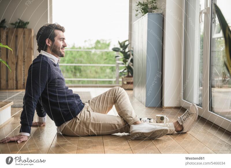 Young man sitting on floor, looking out of window, relaxing Businessman Business man Businessmen Business men getting away from it all Getting Away From All