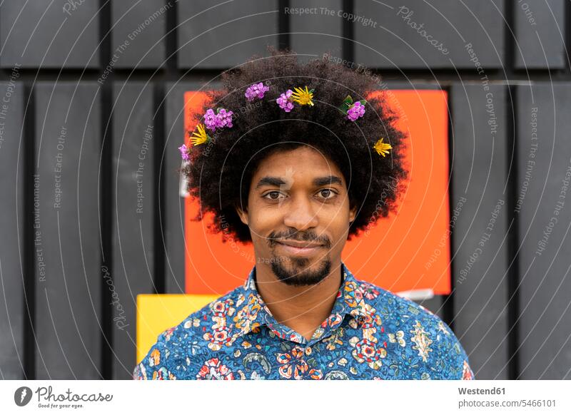 Portrait of man with blossoms in his hair wearing colorful shirt human human being human beings humans person persons African black black ethnicity coloured