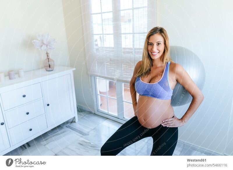 Portrait of smiling pregnant woman practicing with fitness ball Pregnant Woman smile females women portrait portraits Fitness Ball Fitness Balls Balance Ball