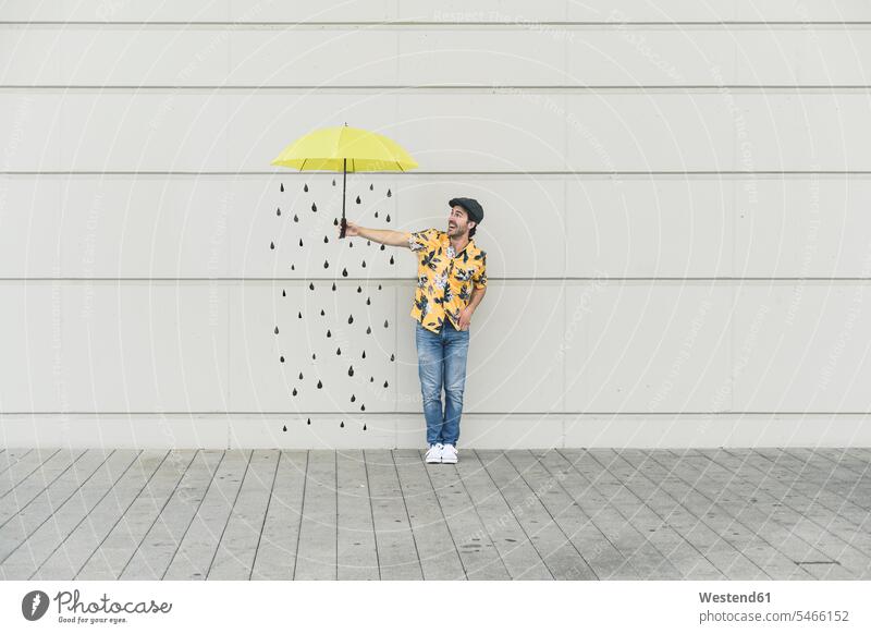 Digital composite of young man holding an umbrella at a wall with raindrops human human being human beings humans person persons caucasian appearance