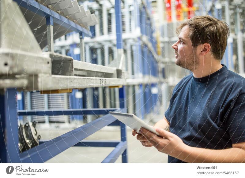 Worker using tablet in factory warehouse Occupation job jobs profession professional occupation blue collar blue collar worker blue-collar worker workers
