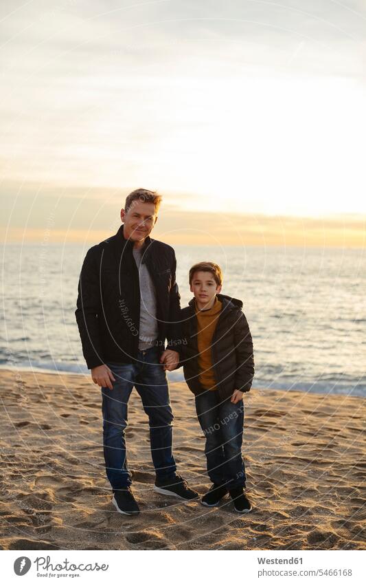 Portrait of father and son standing on the beach sons manchild manchildren pa fathers daddy dads papa beaches portrait portraits family families people persons