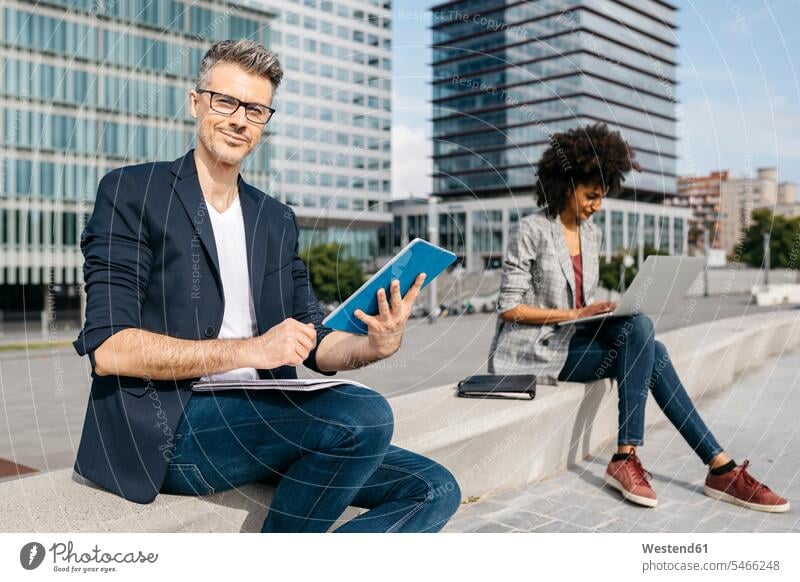 Portrait of confident businessman and businesswoman working outside office building At Work businesswomen business woman business women Businessman Business man