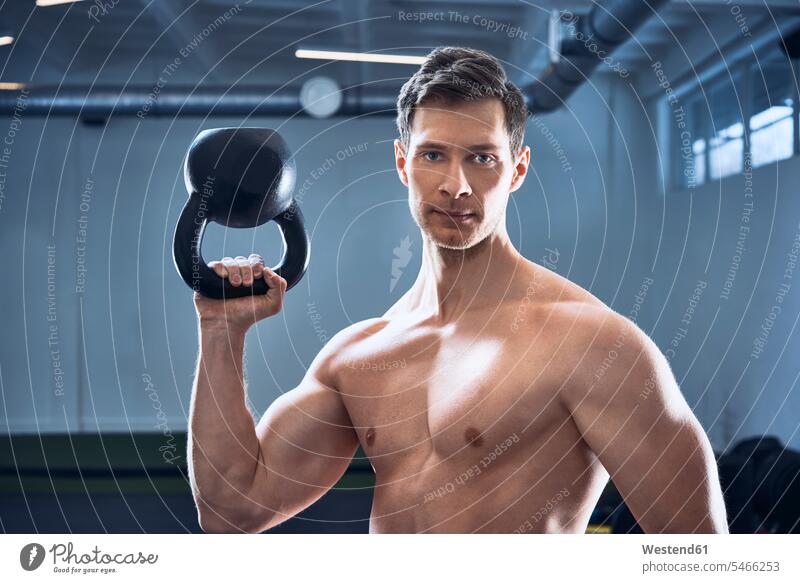 Athletic shirtless man posing with kettlebell at gym sportive sporting sporty athletic pose Posed Kettlebell Kettle bells Kettlebells workout working out
