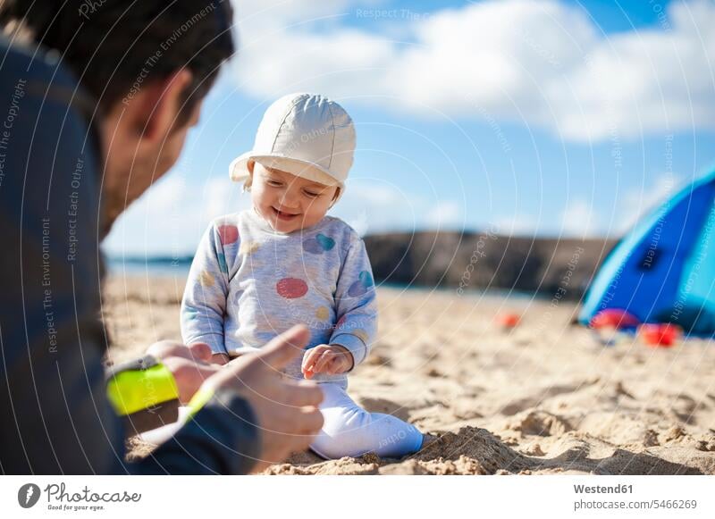 Spain, Lanzarote, happy baby girl playing with father on the beach fathers daddy dads papa beaches happiness daughter daughters baby girls female infants