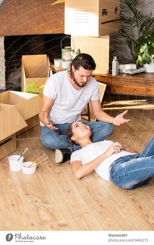 Couple with cardboard boxes in new home having a break Cardboard Carton carton Cardboards cartons moving house move Moving Home at home apartment flats