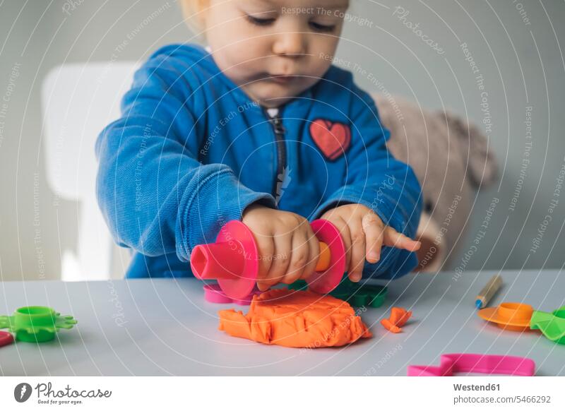 Baby girl playing with modeling clay putty plasticine modelling clay play clay play dough baby girls female babies infants people persons human being humans