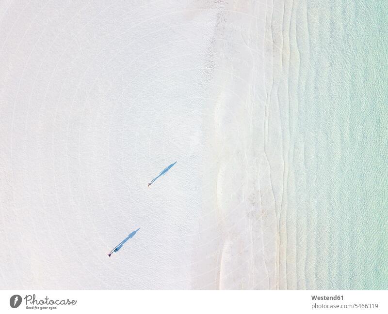 Two people and their shadows at a beach with crystal clear water seen from above, Yucatan, Mexico touristic tourists summer time summertime summery fair light