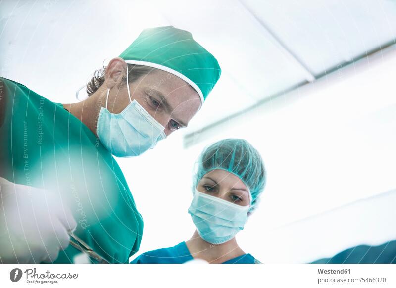 Surgeon performing surgery with nurse in operating room at hospital color image colour image South Africa indoors indoor shot indoor shots interior