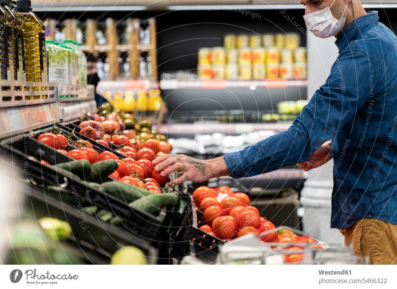 Midsection of man wearing face mask buying vegetables in supermarket color image colour image Spain leisure activity leisure activities free time leisure time