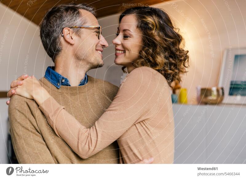 Happy affectionate couple at home jumper sweater Sweaters Eye Glasses Eyeglasses specs spectacles smile embrace Embracement hug hugging delight enjoyment