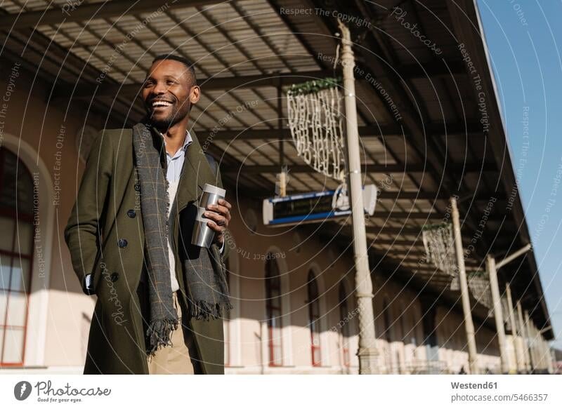 Happy stylish man with reusable cup waiting for the train business life business world business person businesspeople Business man Business men Businessmen