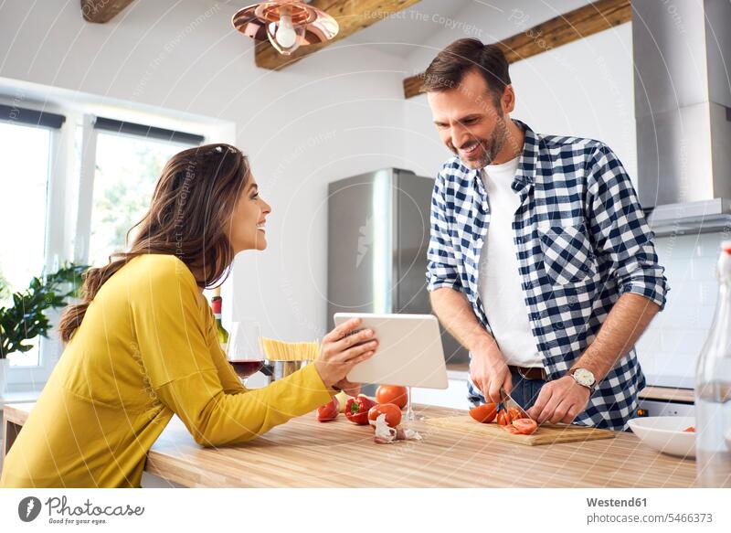 Affectionate couple in kitchen, preparing spaghetti toghether, using digital tablet Food Preparation preparing food domestic kitchen kitchens together happiness