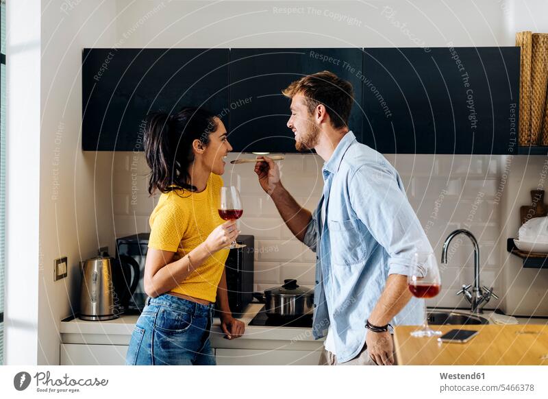 Happy young couple cooking and drinking wine in the kitchen at home together Drinking Glass Drinking Glasses Wine Glasses Wineglass Wineglasses Cooking Pots