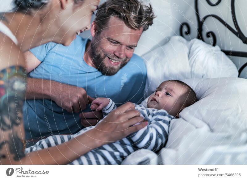Happy parents with their baby in bed human human being human beings humans person persons caucasian appearance caucasian ethnicity european Mixed Race