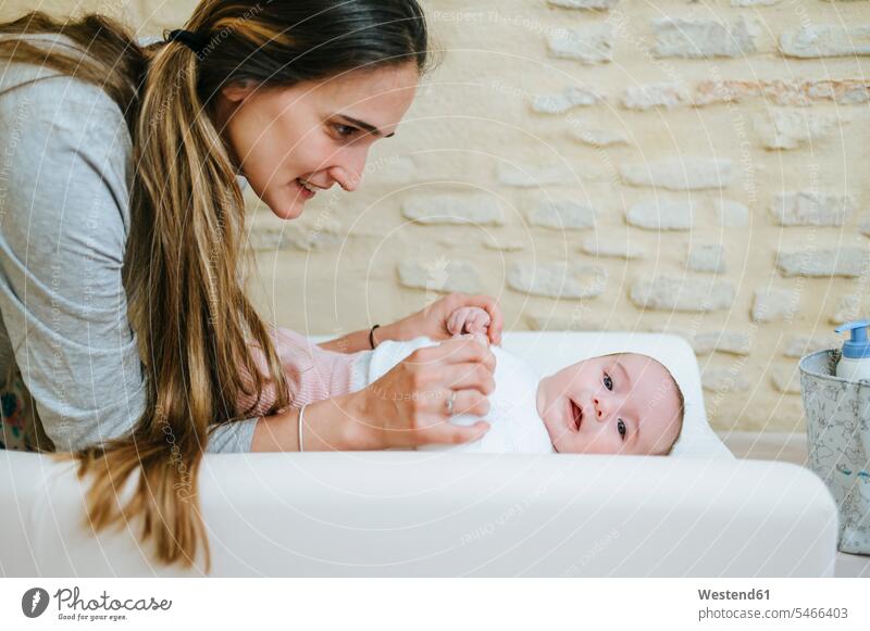 Mother looking at her baby on changing table human human being human beings humans person persons caucasian appearance caucasian ethnicity european 2 2 people