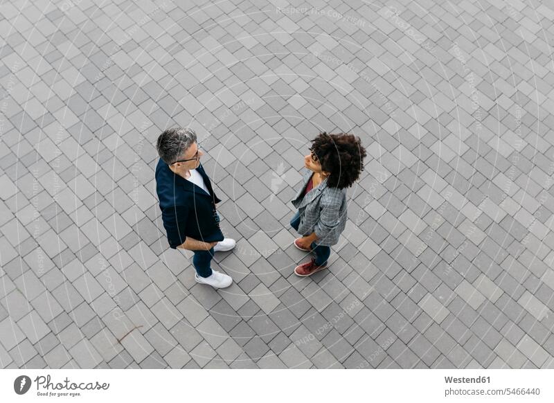 Top view of two colleagues talking on a square plaza places Public Square speaking caucasian caucasian ethnicity caucasian appearance european Female Colleague