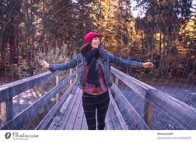 Woman wearing red woolly hat and denim jacket on a bridge in autumn human human being human beings humans person persons caucasian appearance