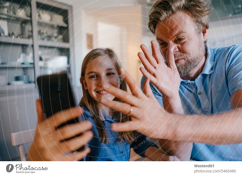 Playful father and daughter taking a selfie at home sitting Seated together Hand Sign hand gesture hand signal human hand hands human hands positive playful