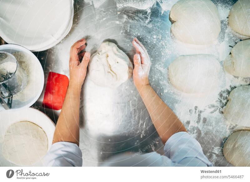 Baker working with dough in bakery bakers At Work bakeries craftsman trade craftsmen Craft Occupation Manual Workers manual laborour handworker Tradesman