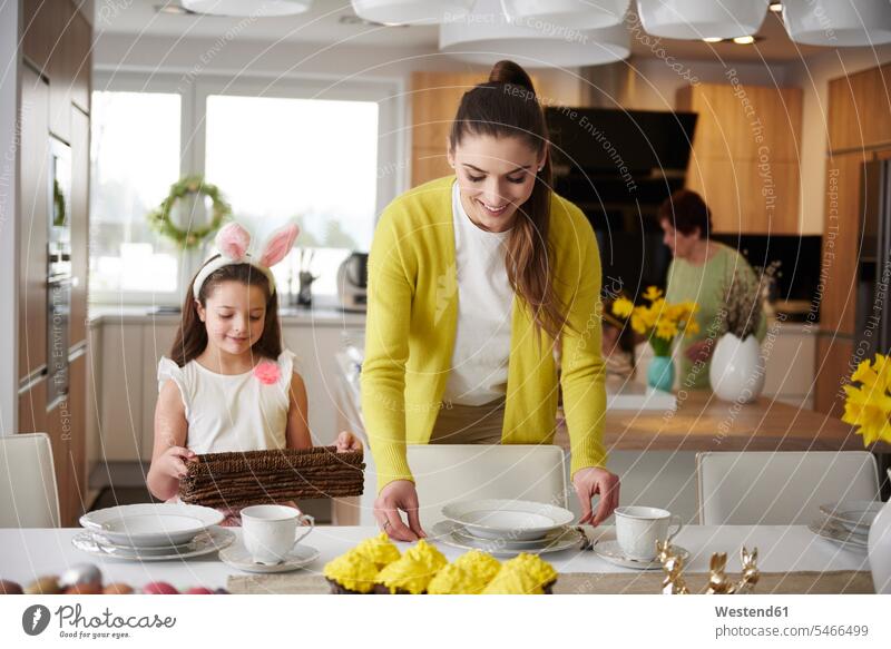 Smiling mother and daughter setting the table at home together smiling smile daughters mommy mothers ma mummy mama laying the table laying table lay the table